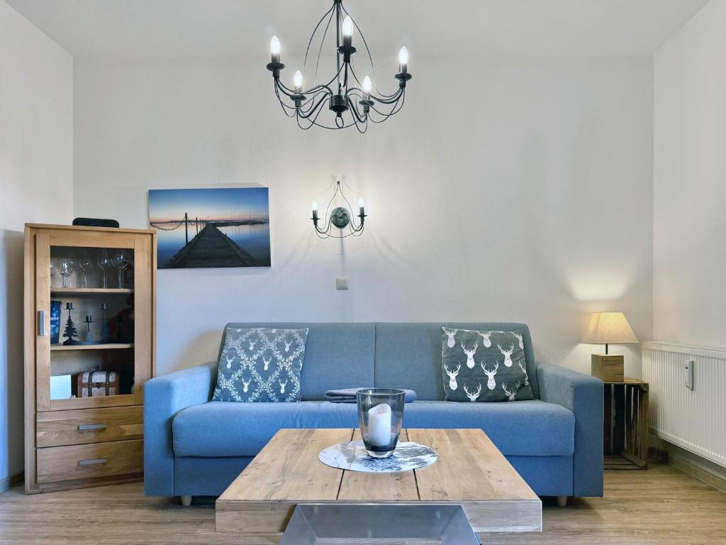 a living room with a blue couch and a table at Sonnenhof Seeg 05 in Seeg