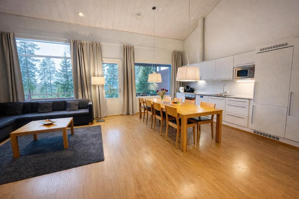 a kitchen and living room with a table and a couch at Kylpyla Spa Villa Saimaan Harmonia in Imatra