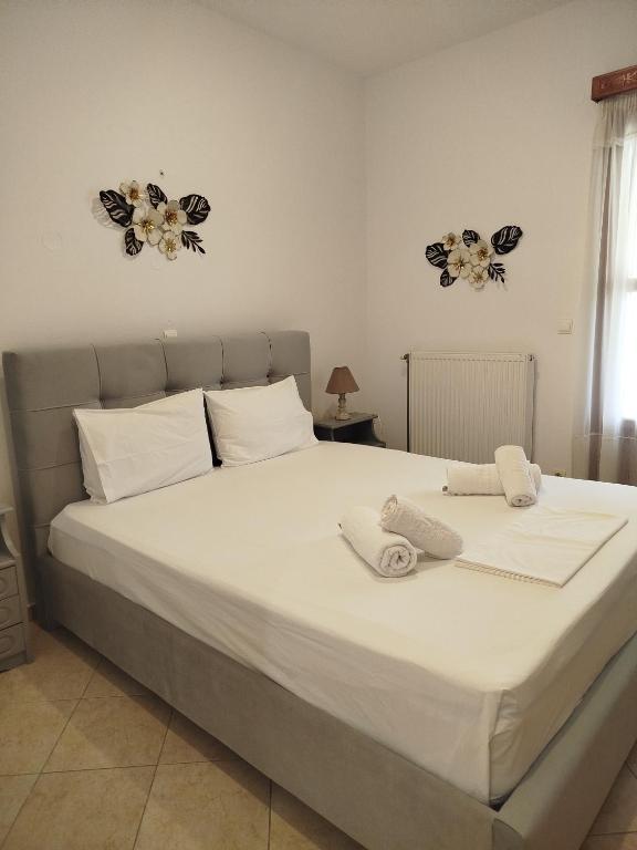 a bedroom with a large white bed with towels on it at Margarita's home in Nísos Skýros