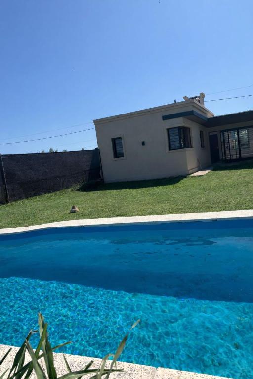 a large blue swimming pool in front of a house at Casa Serena in Capitán Bermúdez