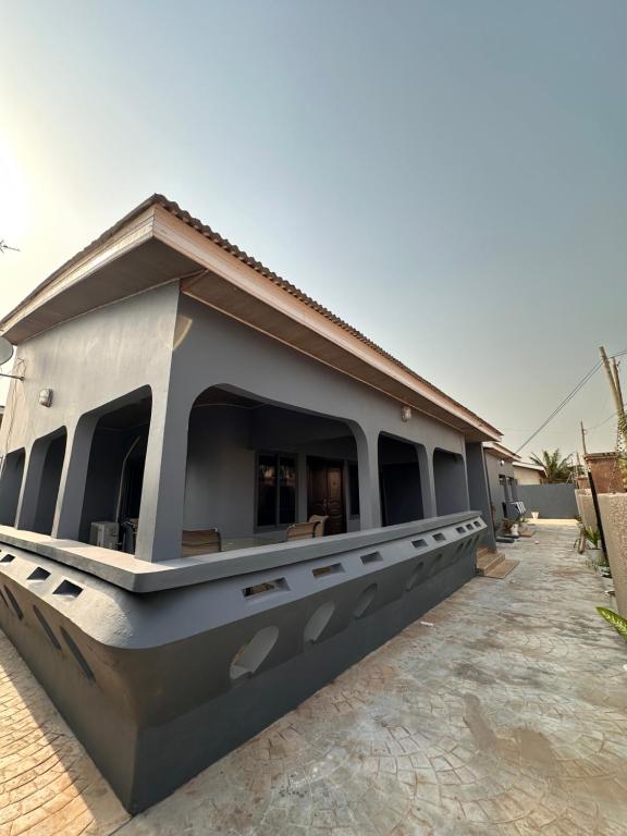 a small building with a roof on a sidewalk at C&B House MV in Accra