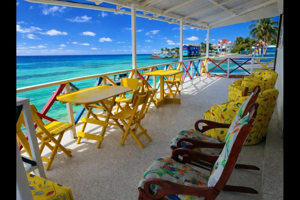 a balcony with tables and chairs and the ocean at Inn Skyline Hostel in San Andrés
