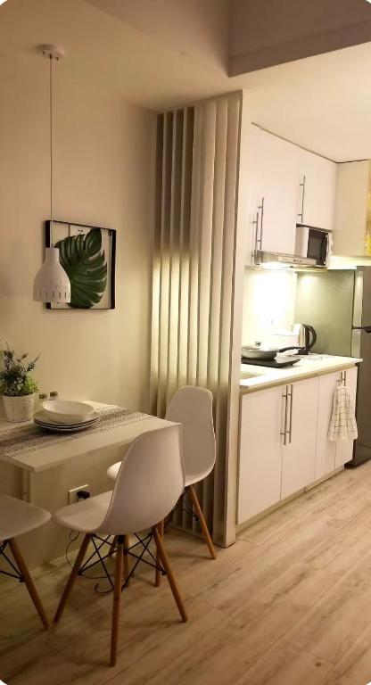 a kitchen with a table and chairs in a room at Sunvida tower Unit 1911 in front Sm Cebu in Cebu City