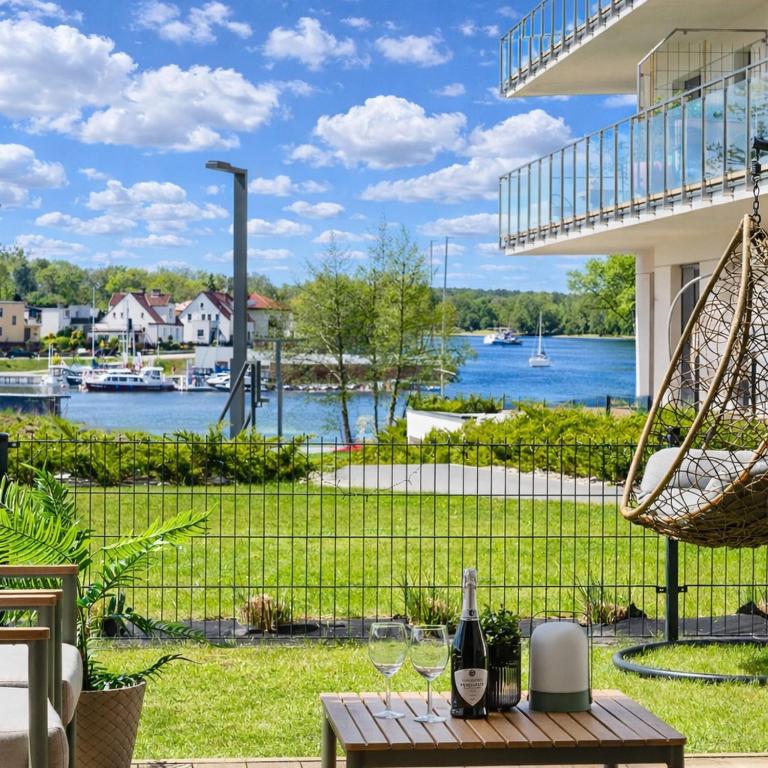 a patio with a view of the water at ApartView - ogród, taras, winda, widok na Jeziorak, Netflix i Max, parking in Iława