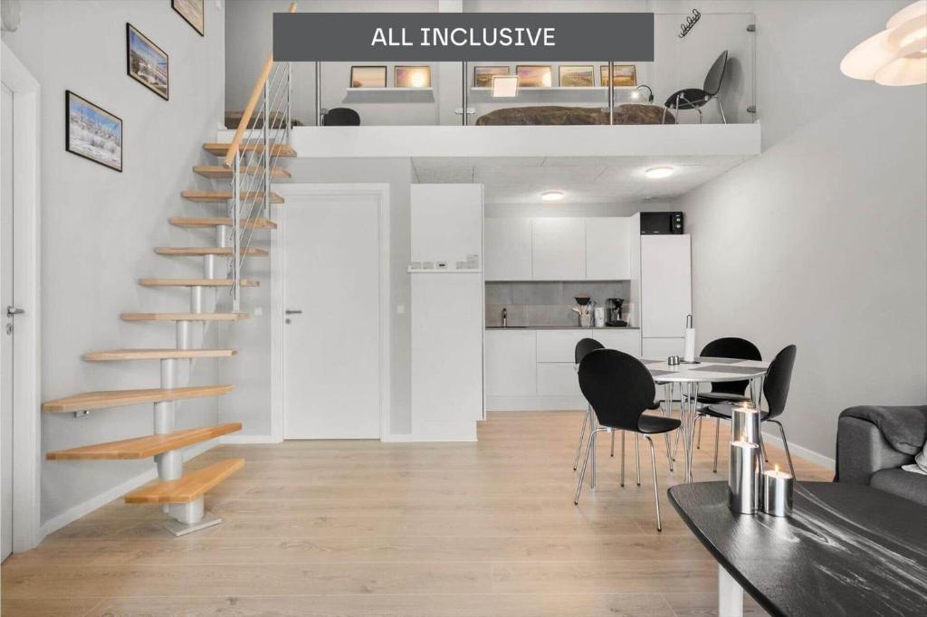 a living room with a staircase and a table and chairs at 776-Hvide-Sande-Norregade-2-nr-27 in Hvide Sande