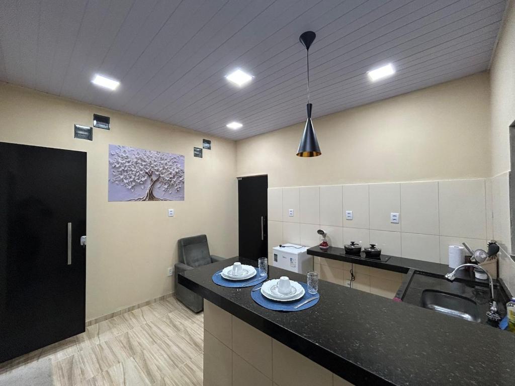 a kitchen with a sink and a counter with plates on it at Loft Marajó Superior in Soure