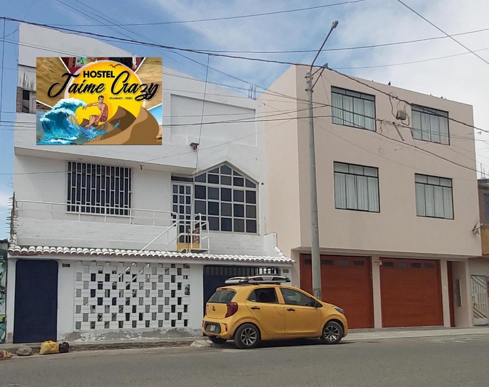 a yellow car parked in front of a building at JaimeCrazyhostel in Huarmey