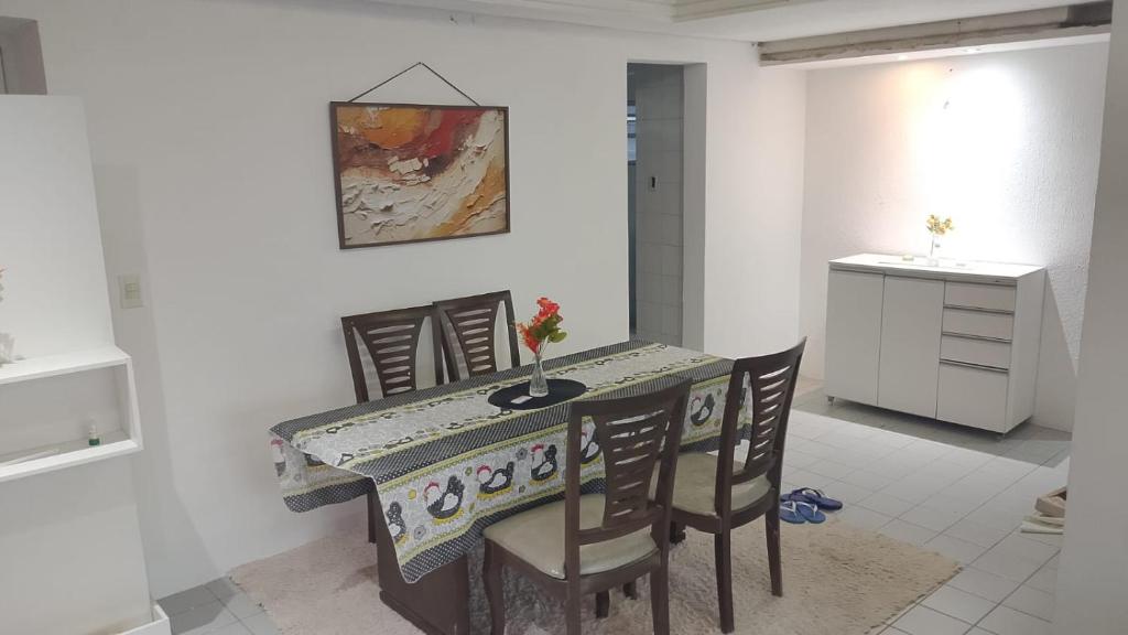 a dining room with a table with chairs and a painting at Levi in Recife