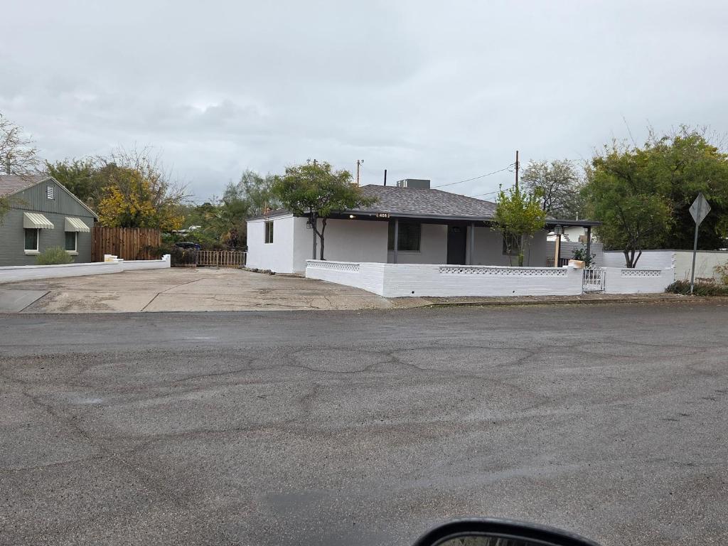 a house with a white fence and a driveway at Quiet Desert Oasis off Swan Rd in Tucson