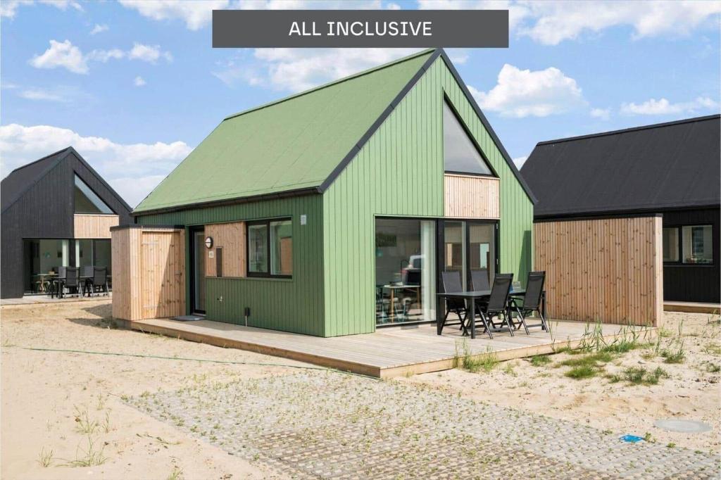a house with a green roof on a wooden deck at 944-Hvide-Sande-Langsand-143 in Hvide Sande