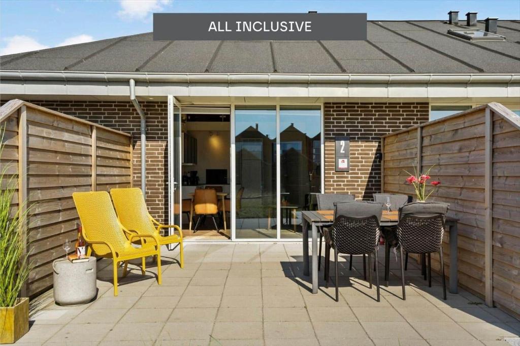 a patio with chairs and a table in front of a building at 777-Hvide-Sande-Norregade-2-nr-2 in Hvide Sande