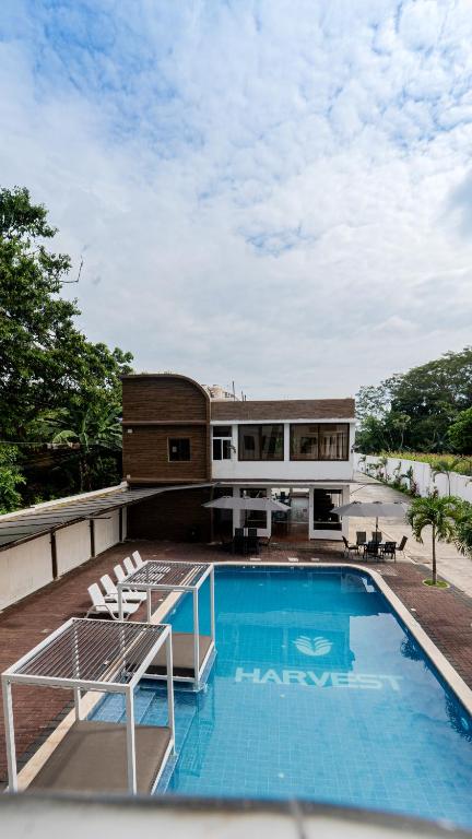 a house with a swimming pool on top of a building at Hotel Harvest Retalhuleu in Santa Cruz Muluá