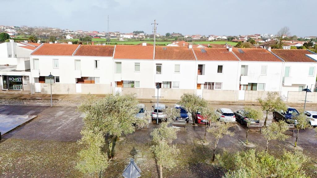 an apartment building with cars parked in a parking lot at Casa Tomé de Sousa in Rates