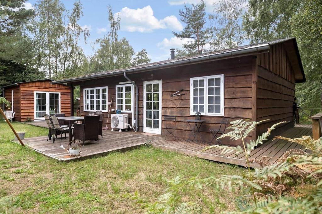a log cabin with a table on a deck at 2002-Stege-Solvgranen-7 in Stege