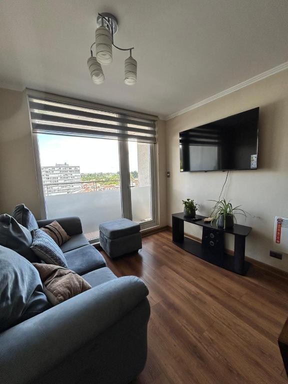a living room with a couch and a large window at Departamento en Temuco O'Higgins in Temuco