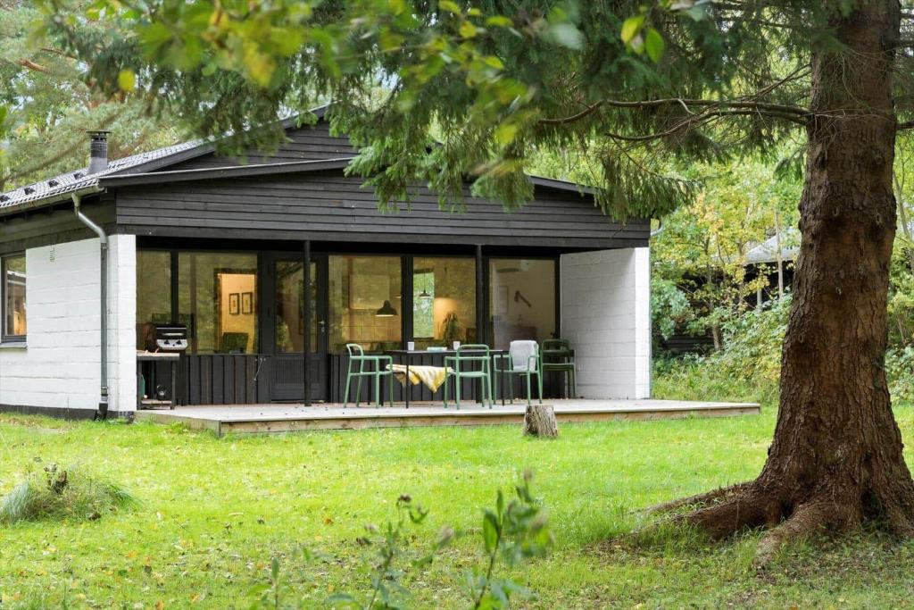 a house with a screened in porch with a table and chairs at 2007-Stege-Aedelgranen-3 in Stege