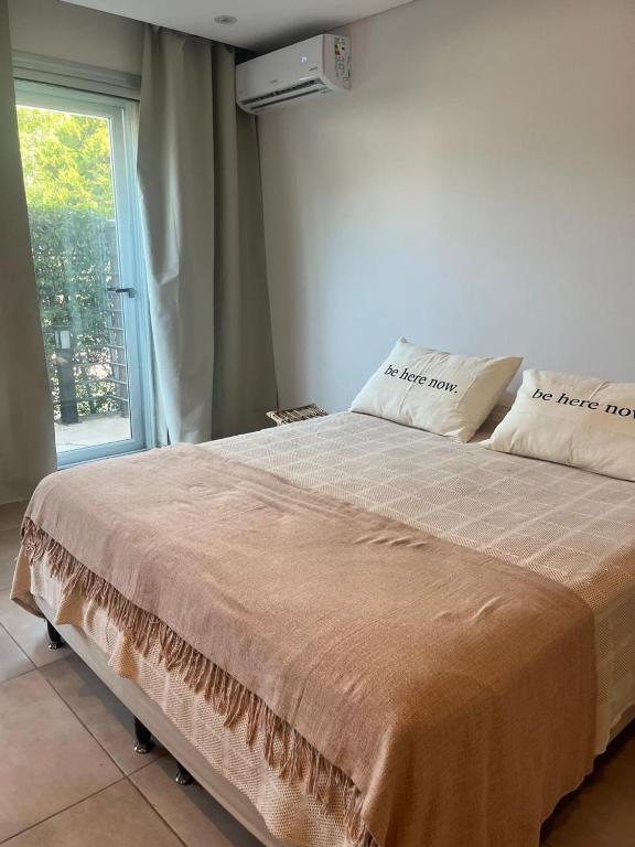 a large bed in a room with a window at Aires Almafuerte in Saladillo