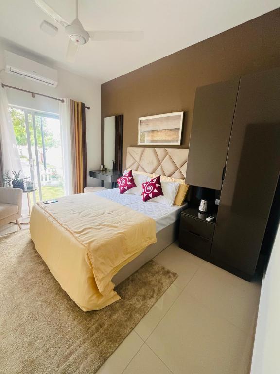 a bedroom with a large bed with red pillows at sixfive negombo in Negombo