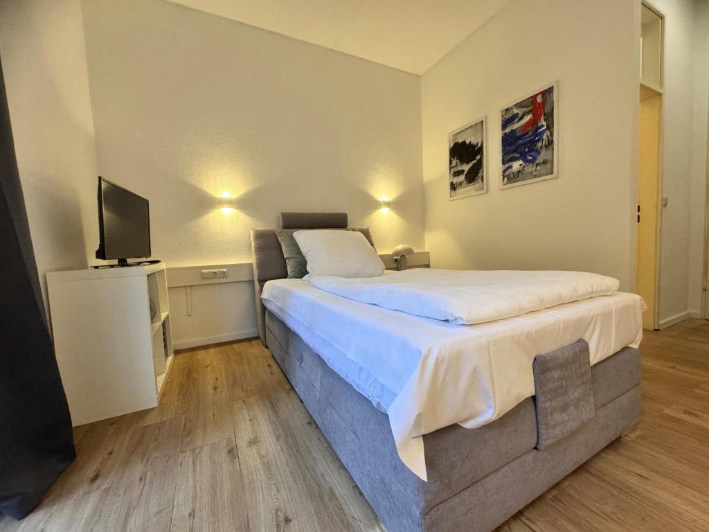 a bedroom with a large bed and a television at Kurhaus im Harz - Bad Harzburg in Bad Harzburg