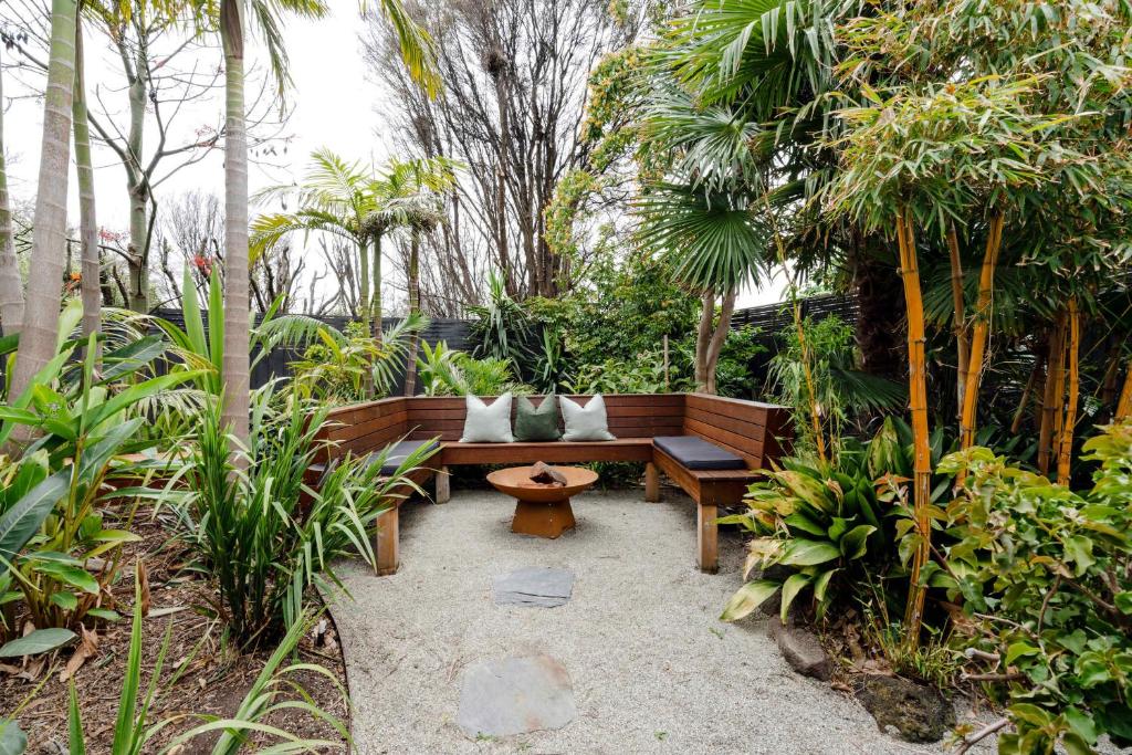 a bench in a garden with trees and plants at The Greenhouse - Spa & Fire - Pet Friendly in Barwon Heads