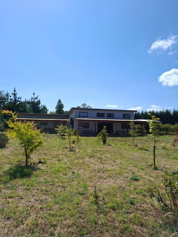 a building in the middle of a field with trees at Casa Campo in Lago Ranco