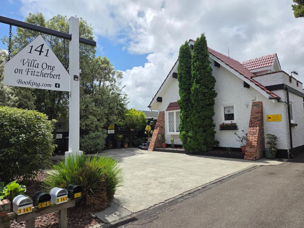 a building with a sign in front of a house at Villa One on Fitzherbert in Palmerston North