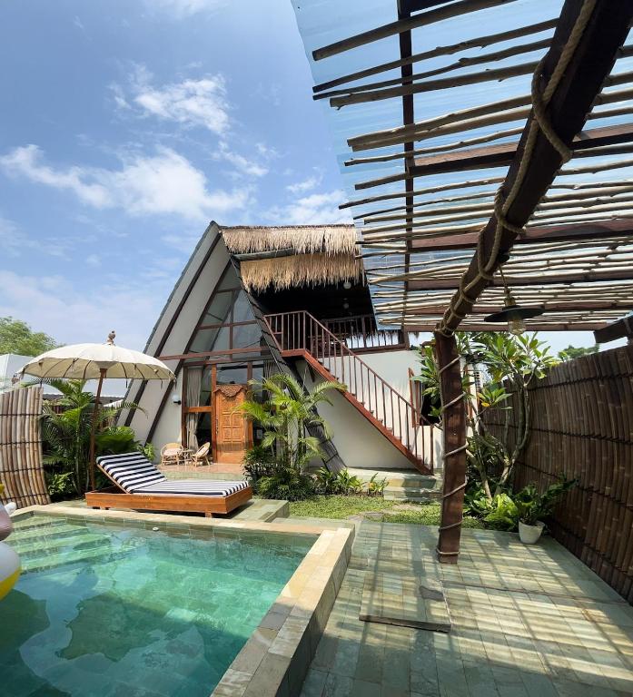 a house with a swimming pool in front of a house at The Phalosaa Villa unit Cabana in Ngaglik