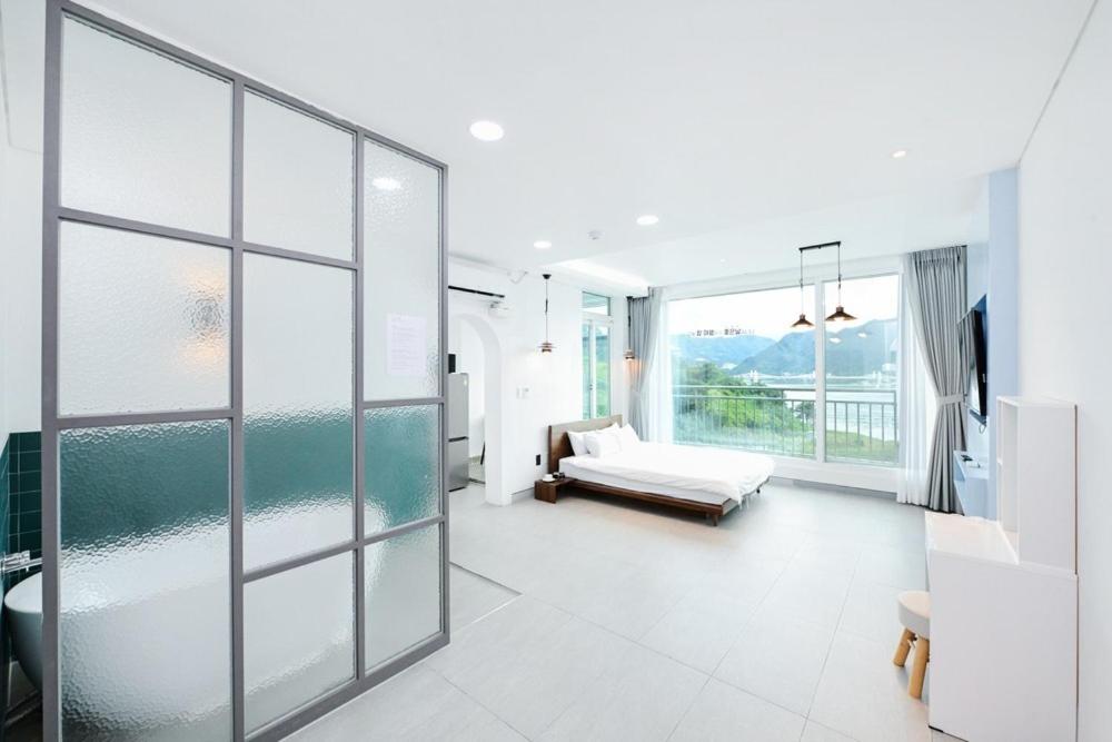 a large white room with a couch and windows at Camp Gate Pension Riverview Spa in Gapyeong