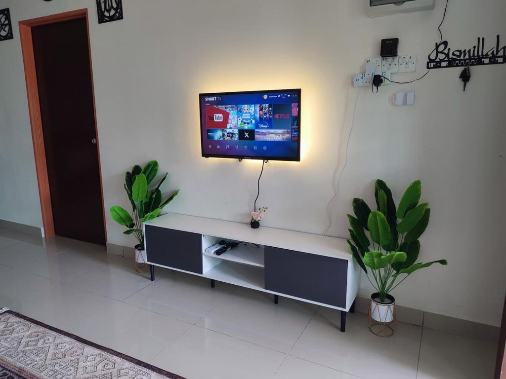 a living room with a tv on a wall at k homestay in Jeli