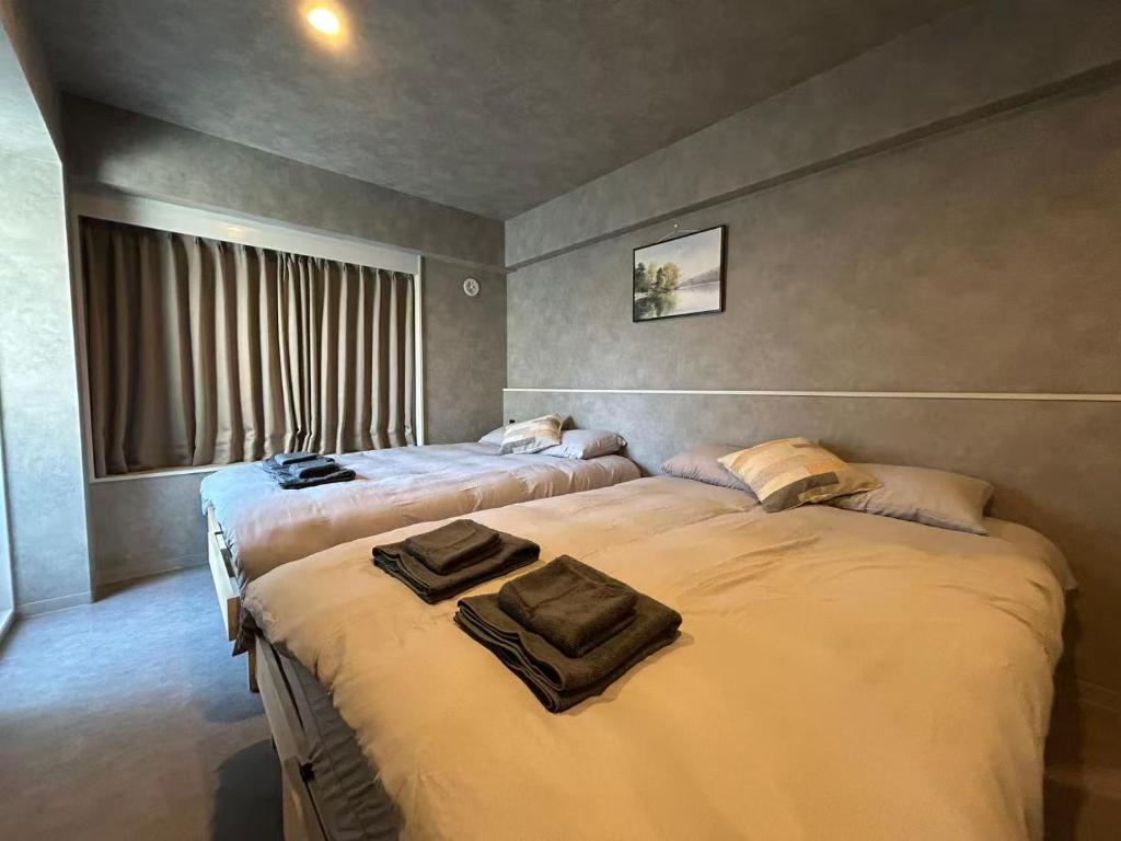 a bedroom with two beds with towels on them at Domo Stay 鳥越 駅近徒歩秋叶原 上野 生活便利 周辺施設充実 in Tokyo
