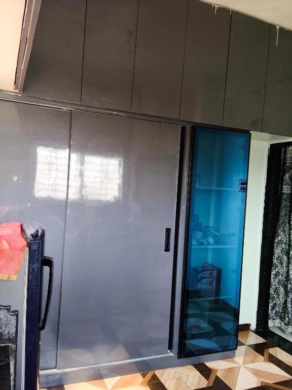 a sliding glass door in a room with a tile floor at Haripriya Guest House 2bhk Solapur in Bāle