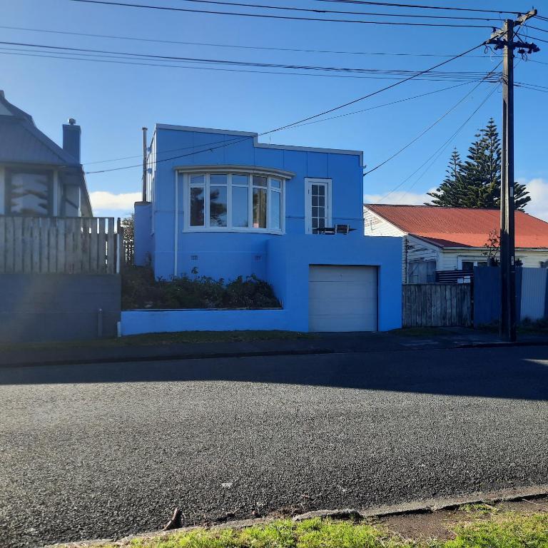 a blue house on the side of a street at Little Blue Bach in Whanganui