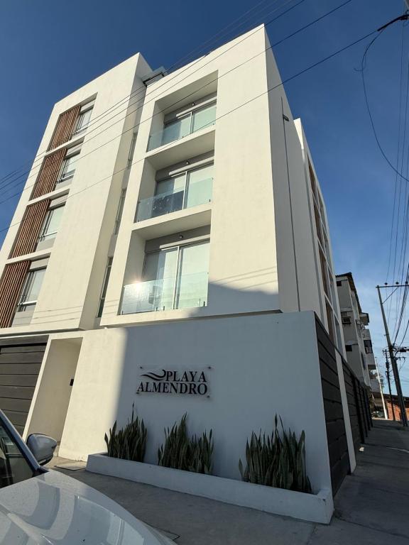 a white building with a sign in front of it at Suite For You - Salinas Chipipe in Salinas