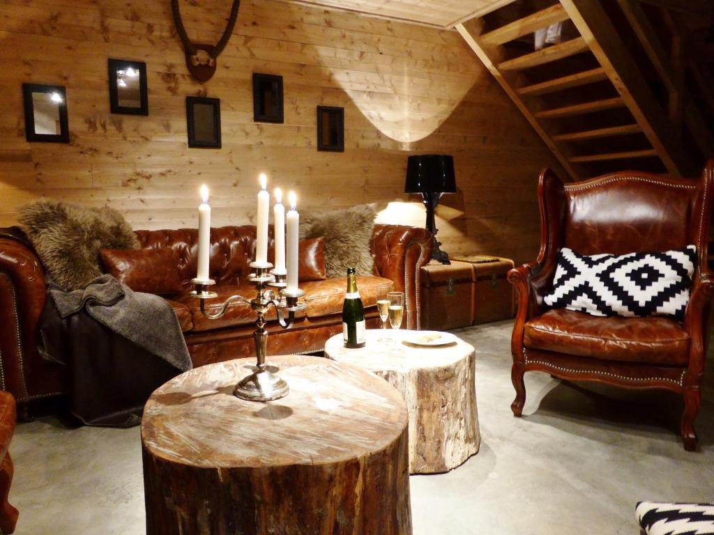 - un salon avec une table en rondins et des bougies dans l'établissement Les Chalets Aquarelle, à Chamonix-Mont-Blanc