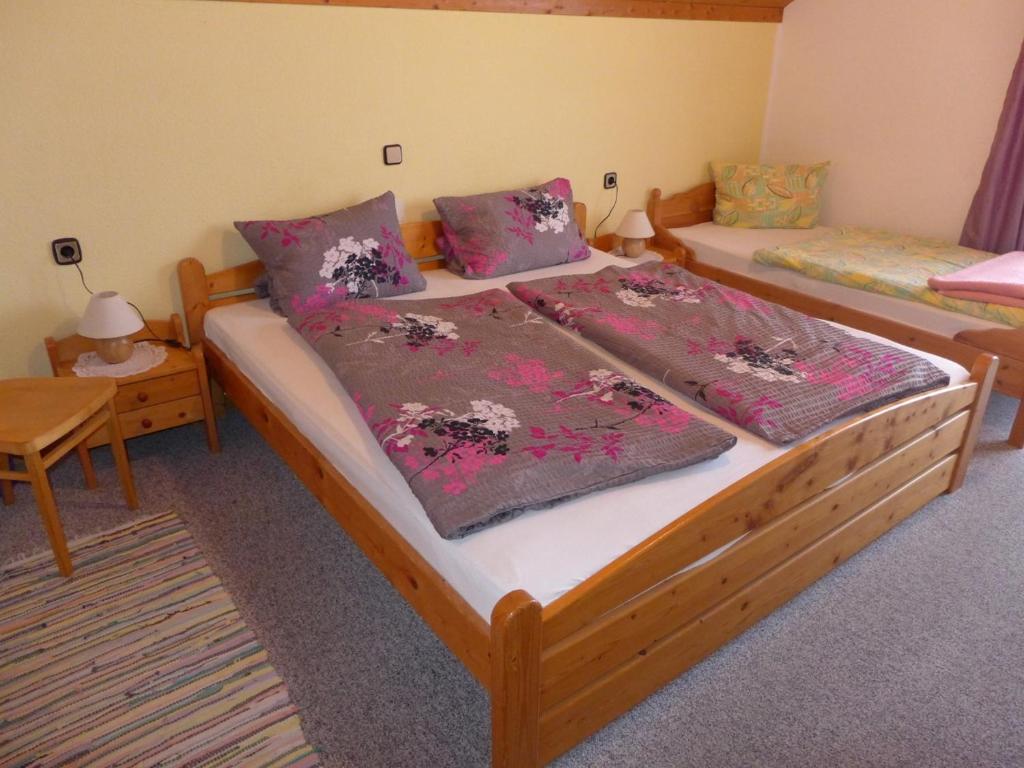 1 dormitorio con 2 camas con mantas y mesa en Gästehaus Zussner en Lochau