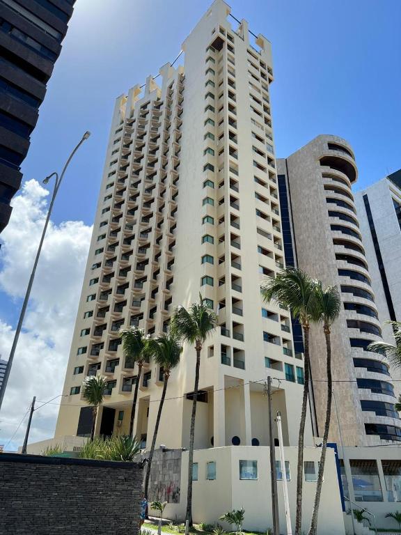 a tall building with palm trees in front of it at Caesar Towers Hotel by Asas Tur in Recife