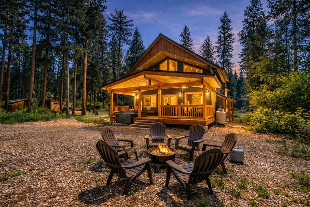 a cabin in the woods with chairs and a table at Compass Cabin by NW Comfy Cabins in Leavenworth