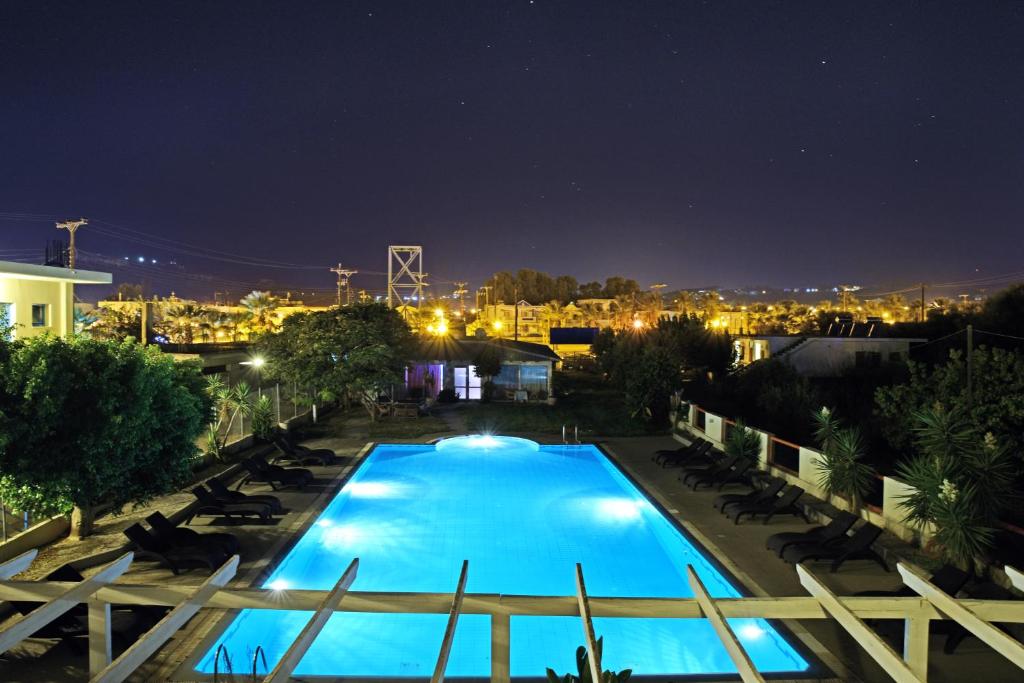 a view of a swimming pool at night at Falirala Central in Faliraki