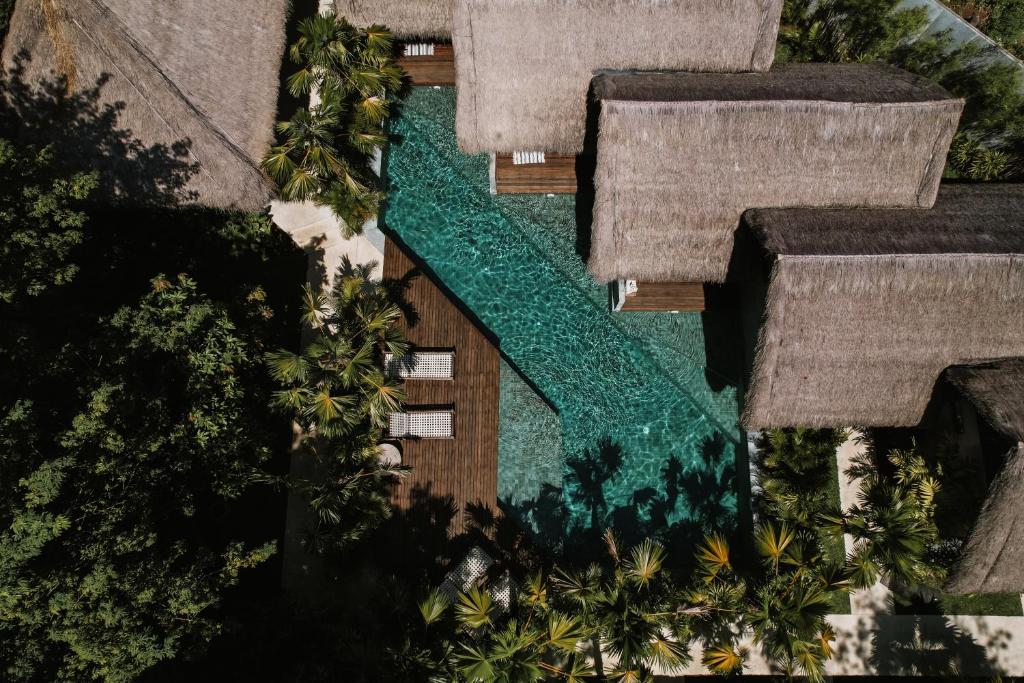 an overhead view of a swimming pool with palm trees at RONJA Boutique Hotel - Adults Only in Uluwatu