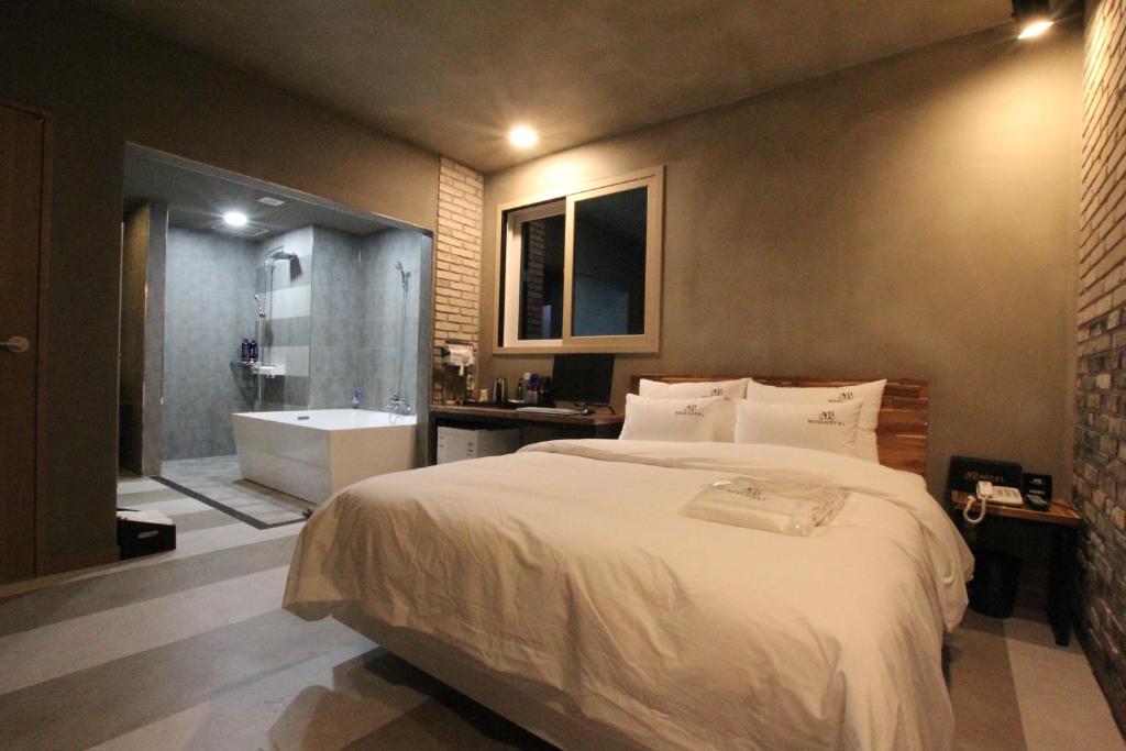a bedroom with a large bed and a bath tub at Nova hotel in Samgong