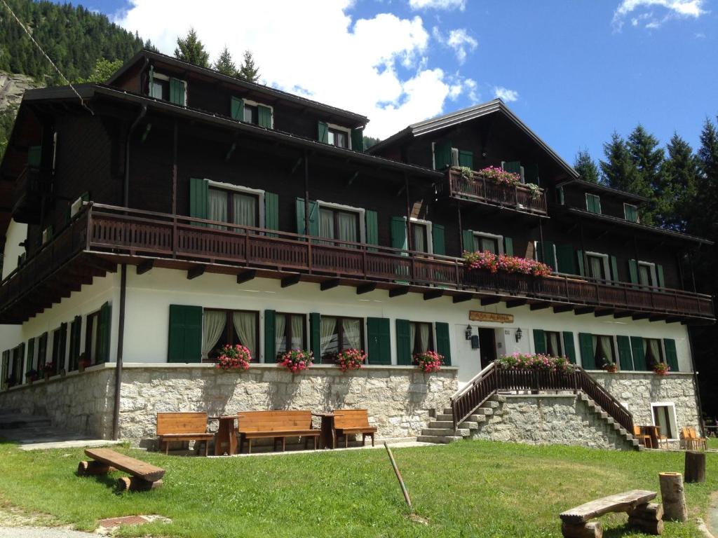 un edificio con una mesa y bancos delante en Casa Alpina Don Guanella, en Macugnaga