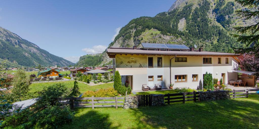 uma casa num campo com montanhas ao fundo em Apart Alpen em Längenfeld