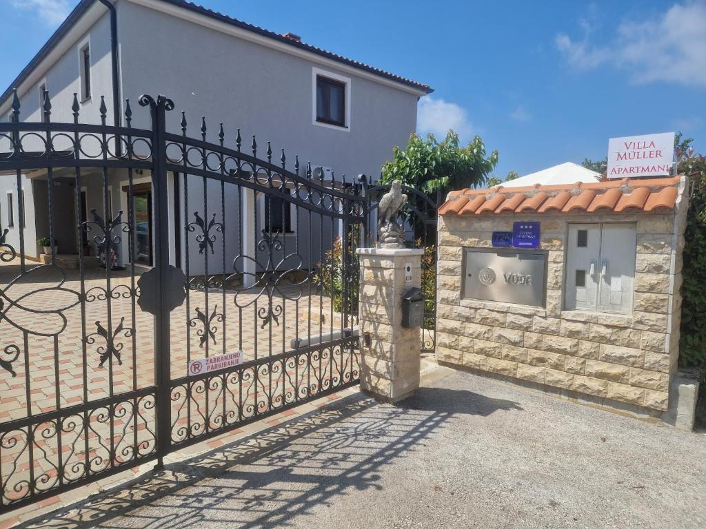 a gate in front of a house with a building at Villa Müller in Poreč
