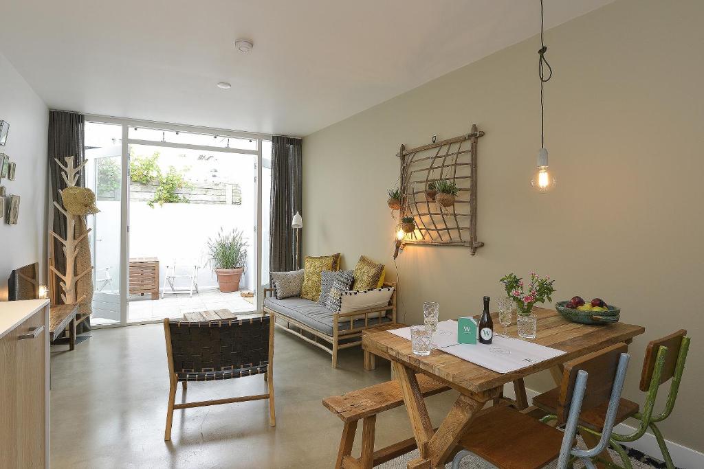 a kitchen and living room with a table and chairs at Follow The Sun Apartment in Zandvoort