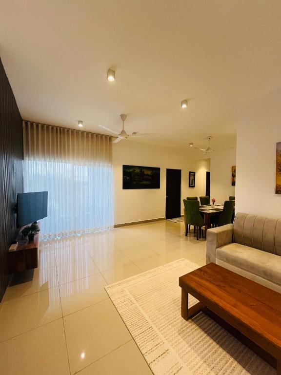 a living room with a couch and a table at Celestial Negombo Resort Apartment ML in Negombo