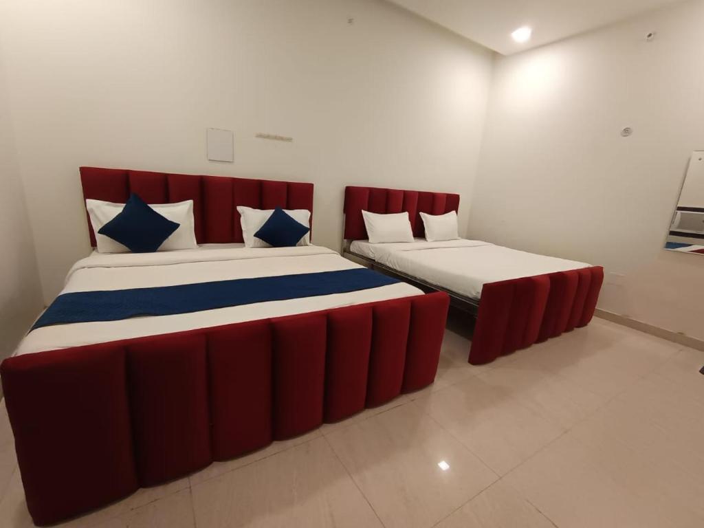 two beds in a room with red and blue at Hotel Shyam Palace Near Kapurthala Mahanagar Lucknow in Lucknow