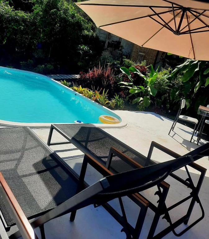 a table and an umbrella next to a swimming pool at Gruta do Pavão in Paraty