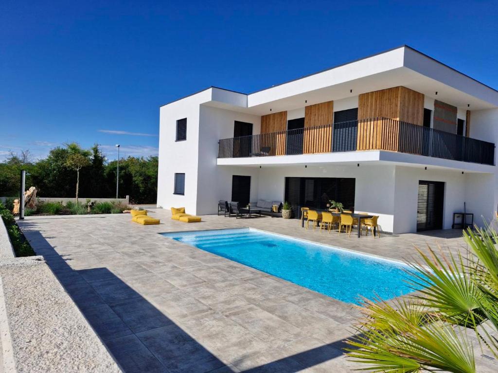 a villa with a swimming pool in front of a house at Villa Atma in Murine