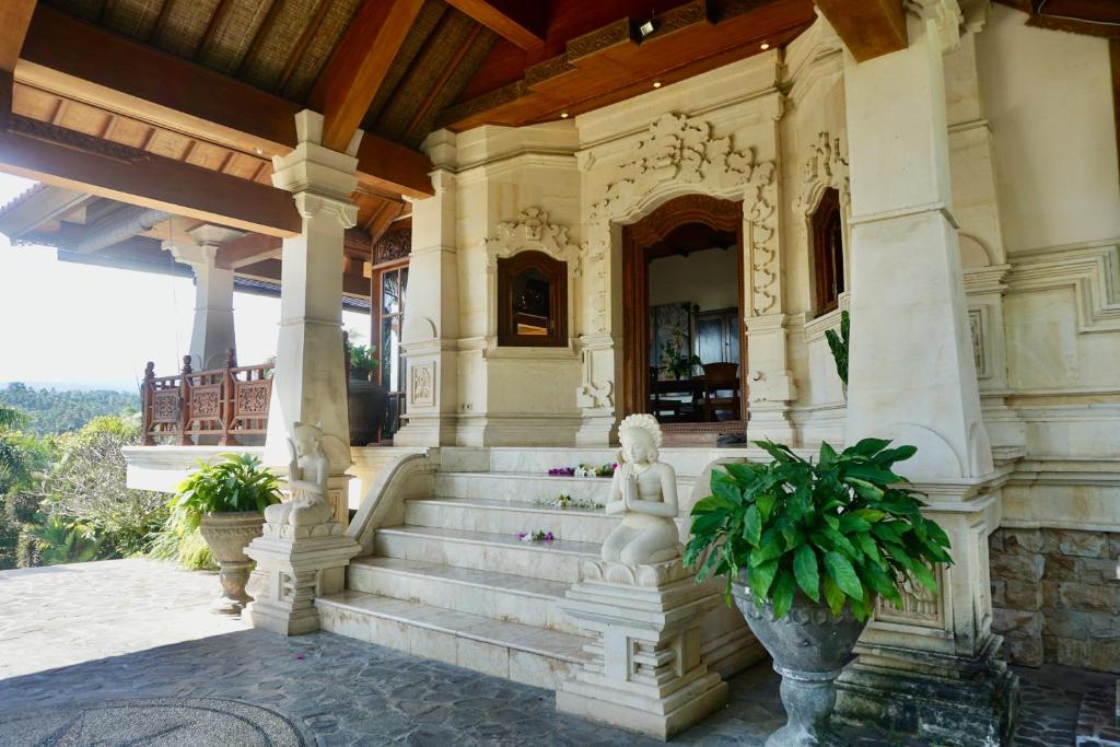 a building with stairs with a statue on it at Gunung Paradis Retreat in Munduk