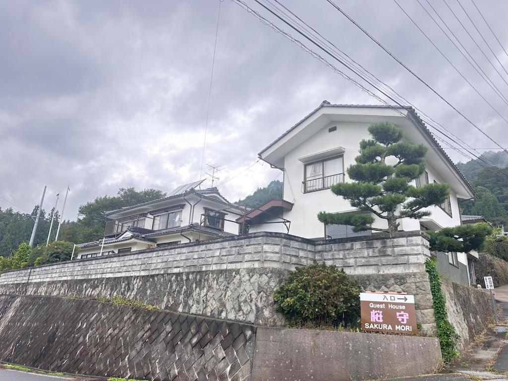 a house on top of a stone wall at さくらもり in Nagano